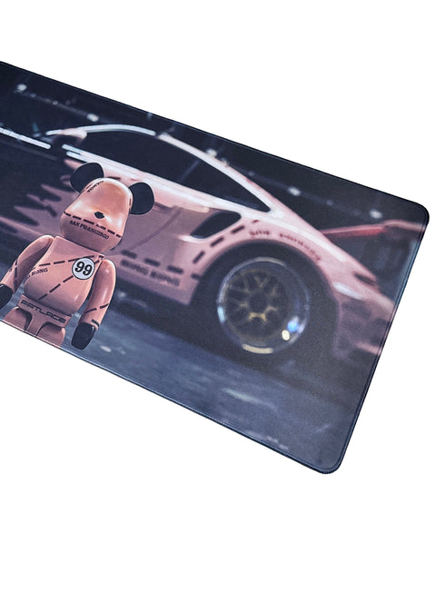 Muismat met combinatie van snelheid en stijl – Bearbrick-stijl figuur en roze auto op zwarte achtergrond